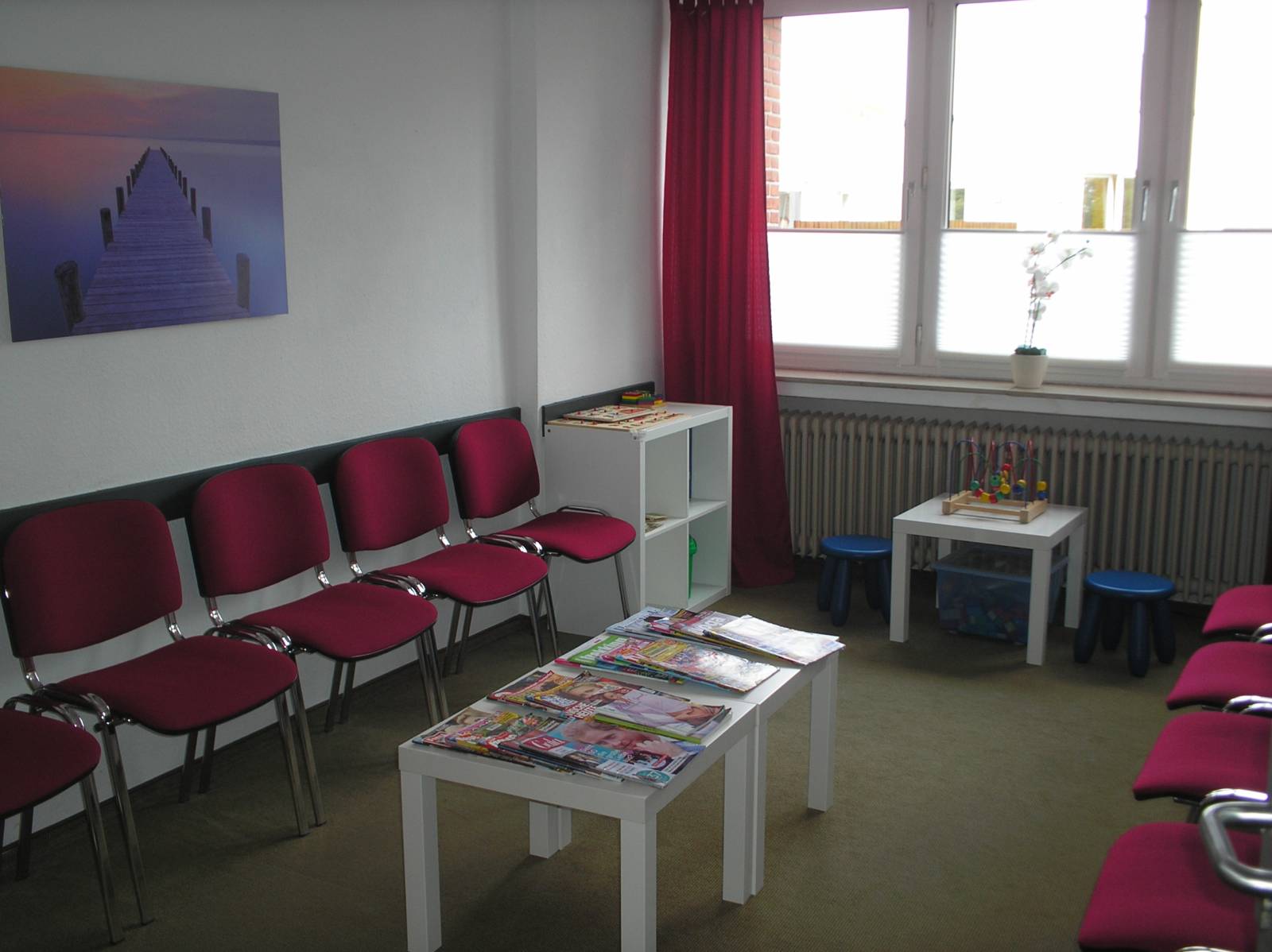 Wartezimmer mit Sitzgelegenheiten und Spielbereich für Kinder